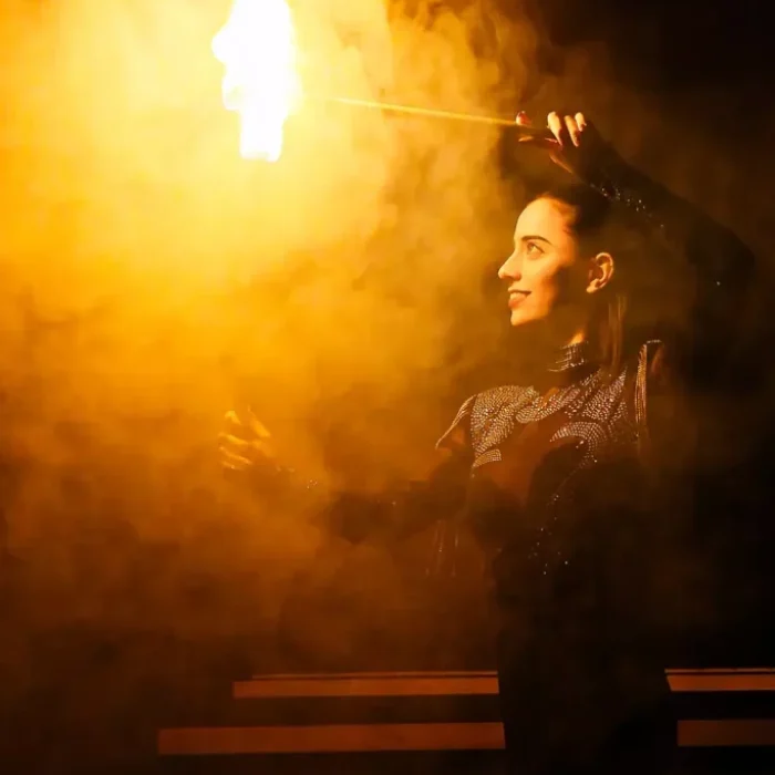 Victoria Plaza, contorsionista, participando en una gran ilusión con fuego durante el espectáculo de magia de La Cena de los Locos